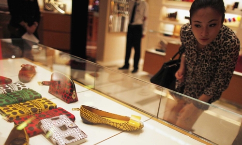Một phụ nữ chọn đồ tại trung tâm thương mại ở Thượng Hải. Ảnh: Reuters