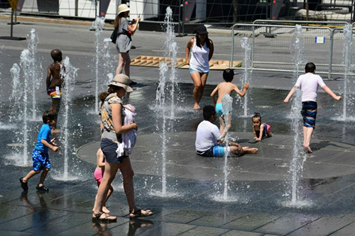 Người dân giải nhiệt ở đài phun nước thành phố Montreal. Ảnh: AFP