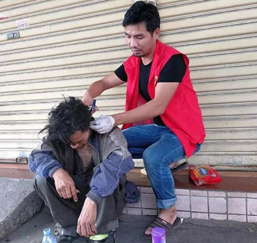 Cai Yanqiu cắt tóc cho một người vô gia cư. Ảnh: People's Daily