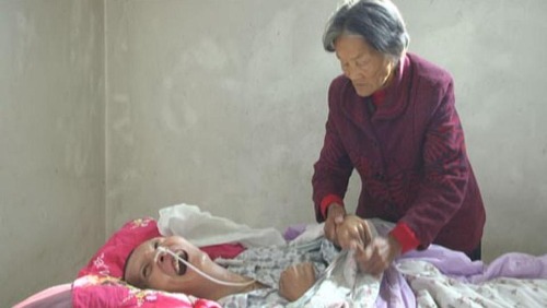 Anh Wang Shubao tỉnh dậy nhìn thấy dòng nước mắt lăn dài trên gương mặt người mẹ già đã chăm sóc anh hơn một thập kỷ qua. Ảnh: Jining News Network.